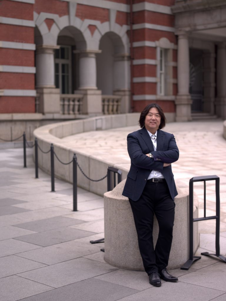 Photo of Ken Honda by a concrete wall