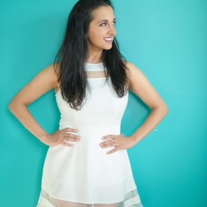 Paula Pant in white dress on teal background