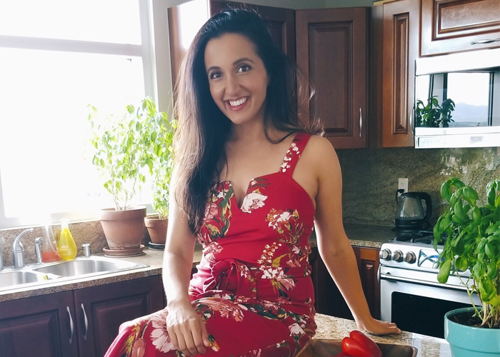 Photo of Paula Pant in kitchen with red floral print dress