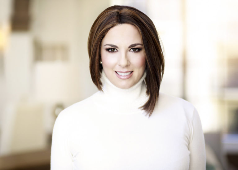Photo of Ash Ambirge, white turtleneck blurry background