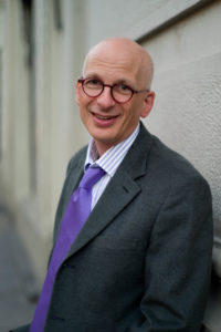 Photo of Seth Godin in a suit with a purple tie