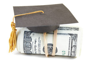 mini graduation cap on rolled up cash