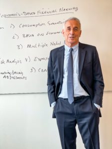 Laurence Kotkiloff in a suit in front of a white board